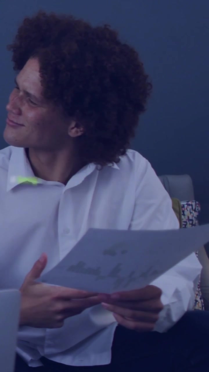 Vídeo vertical: Homem estudando papéis enquanto laptop emite som e código verde sobreposto aparece sobre pessoa em tecnologia