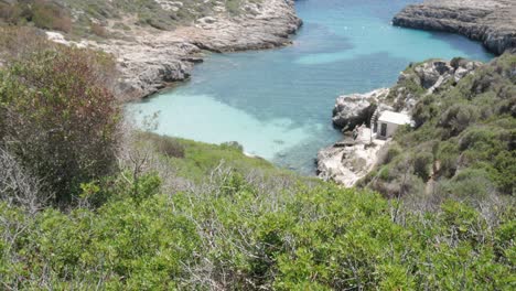 crystal-clear waters of cala binidali with rugged coastline and peaceful nature