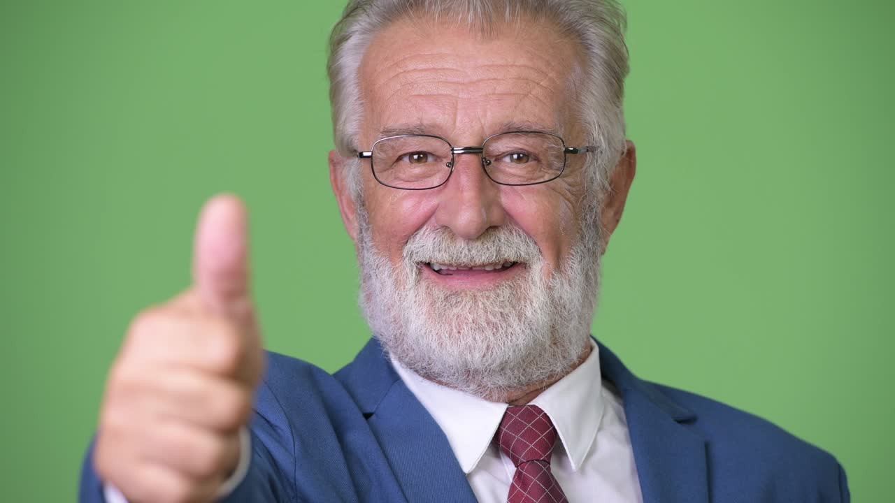 hombre de negocios barbudo y guapo contra un fondo verde.