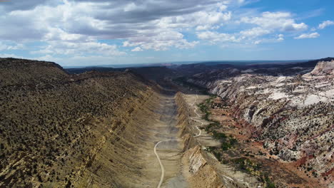 Vista-Aérea-De-Un-Valle-En-Un-Cañón-Atravesado-Por-Una-Carretera