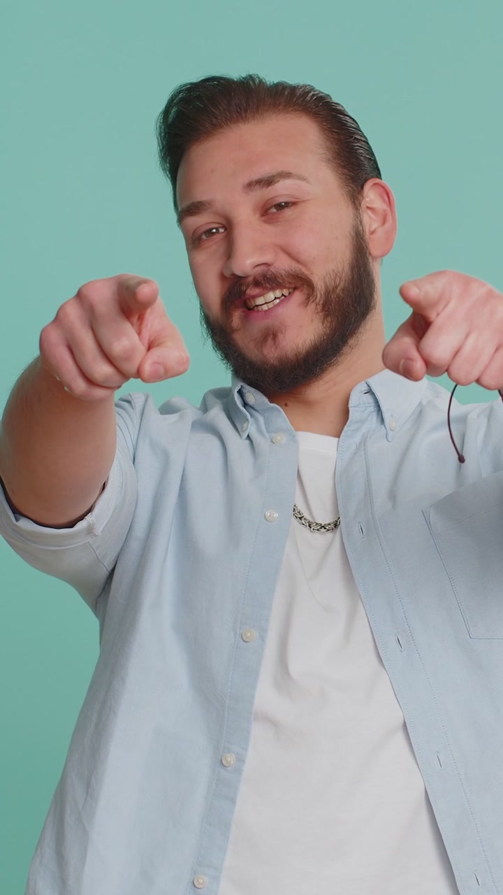 Uomo libanese sorridendo eccitato indicando la telecamera scegliendo fortunato vincitore felice indicando hey you