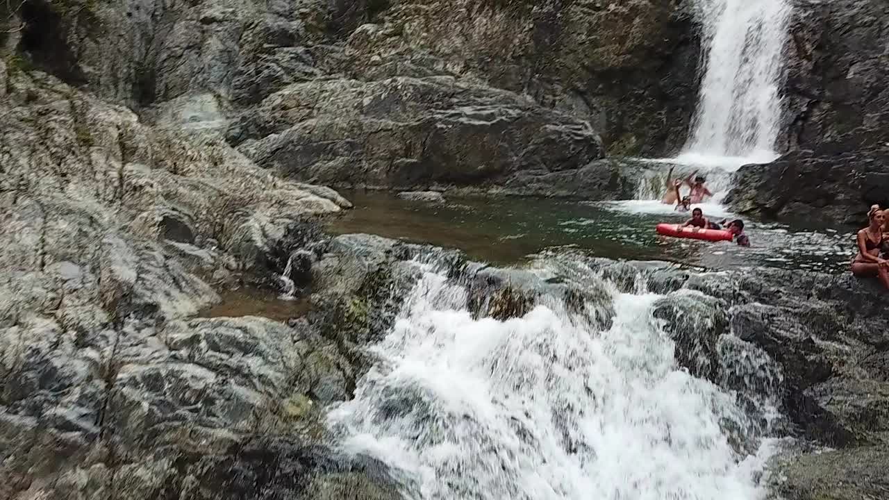 Slowmotion Aerial View of Secluded Charco El Ataud Waterfall and Natural Pools With People Enjoying in Fresh Water, Puerto Rico
