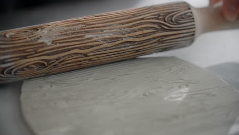 decorating clay with wood-grain rolling pin