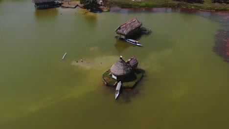 4K-Luftdrohnenvideo-Tagsüber-Mit-Blick-Auf-Ein-Kleines-Haus,-Das-über-Dem-Wasser-Gebaut-Wurde,-Mit-Einem-Boot,-Das-In-Der-Laguna-De-Los-Milagros,-Tingo-Maria,-Peru,-Geparkt-Ist