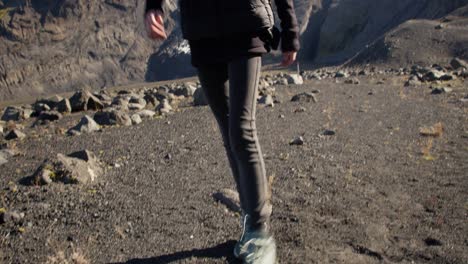 young girl coming from a glacier toward the camera on a sunny day wearing hike clothes