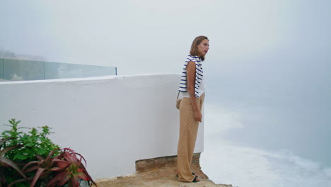 tourist enjoying sea cliff vertical view. lonely traveler exploring city on trip