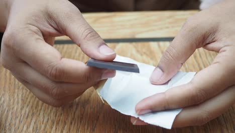 person unwrapping and holding a bar of dark chocolate