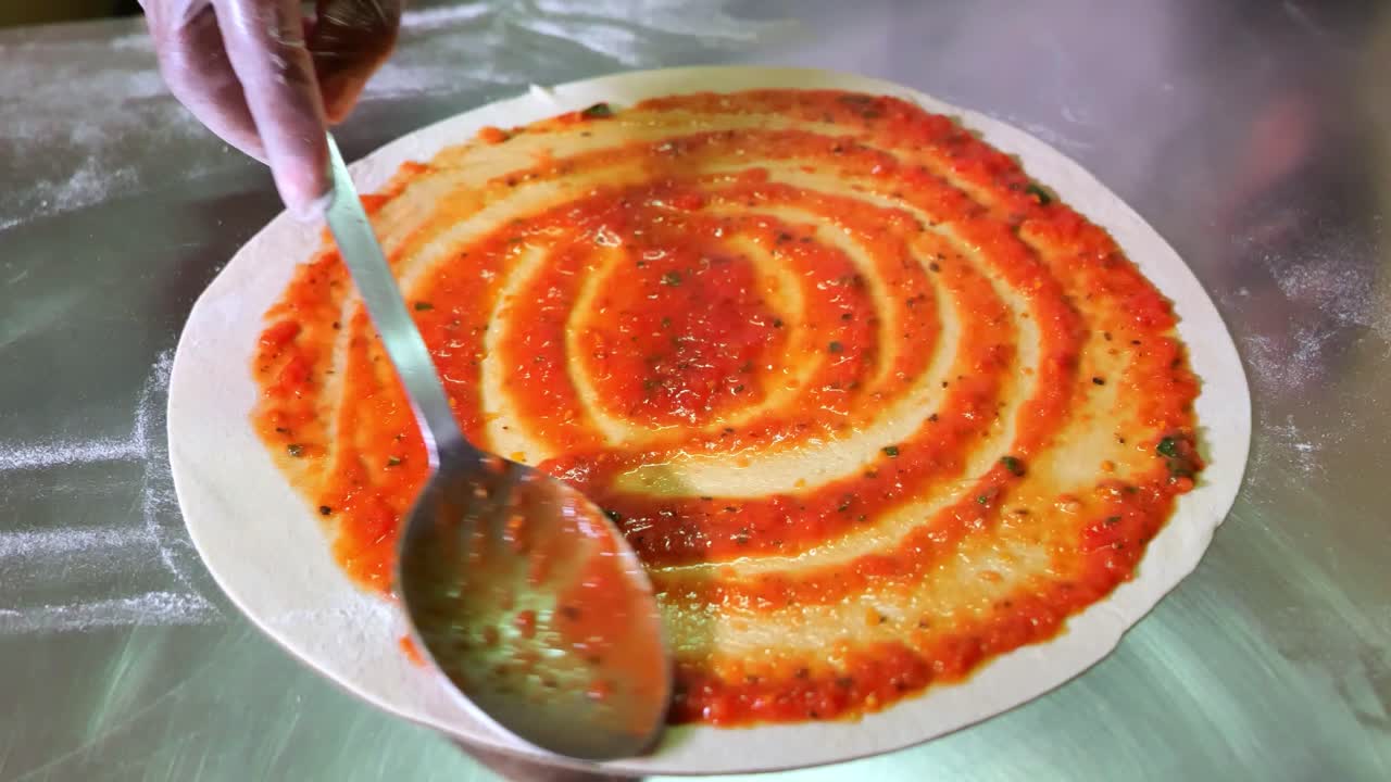 피자 도우 전체에 스푼 피자 소스를 바르고