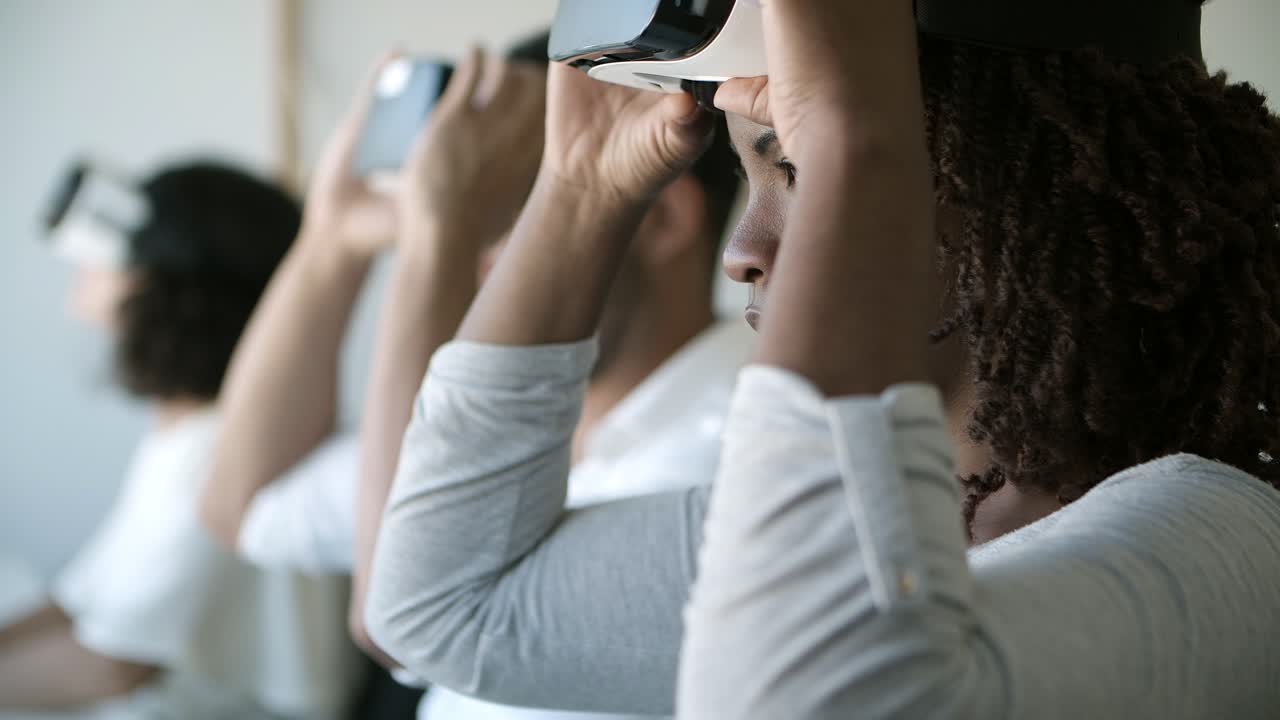 Primo piano di donna che digita sul laptop e indossa un visore VR.