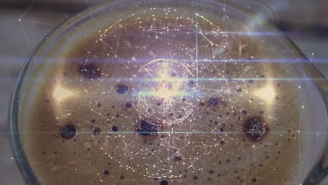 glass coffee cup showing crema bubbles receiving digital network overlay with light streaks