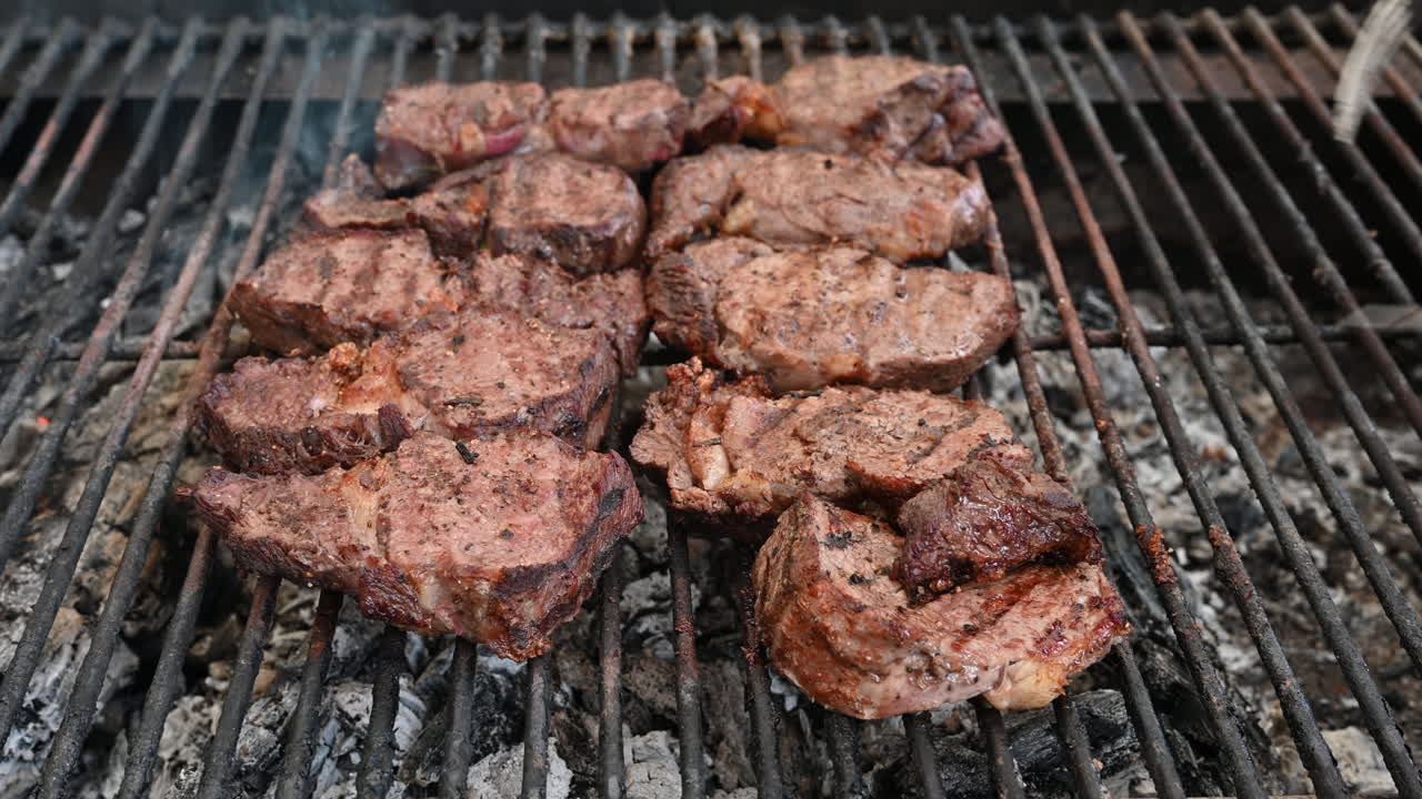 Pieces of beef being prepared on a grill