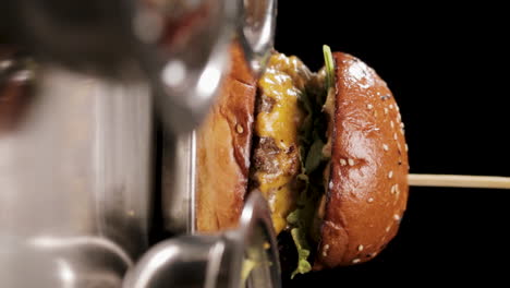 vertical shot of yummy hamburger on wooden stick for serving