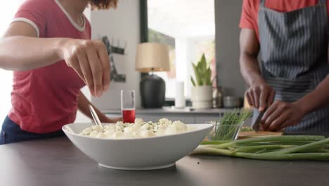 happy diverse friends preapring meal in kitchen, slow motion