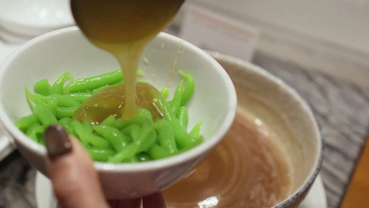 Pouring Sweet Palm Sugar Syrup Over Green Cendol Dessert
