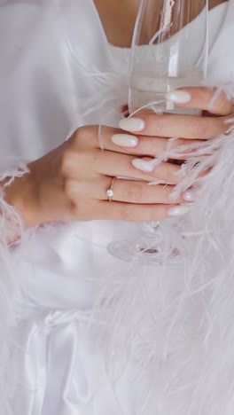 Close-up-view-on-female-hand-holding-glass-of-cold-champagne