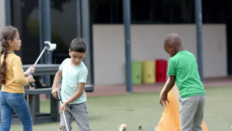 in school, children picking up trash with grabbers, cleaning schoolyard together
