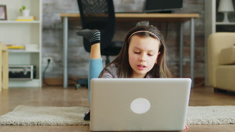 little girl with braces lying on the floor in living room