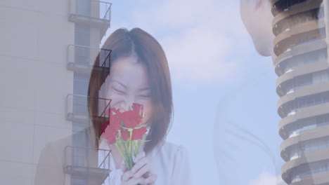 smelling red roses, woman with building and sky animation in background