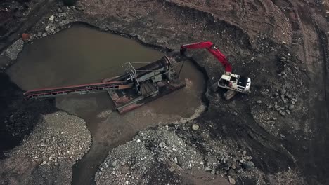 Minería-De-Placer-En-El-Territorio-De-Yukón,-Canadá---Vista-Aérea-De-La-Excavadora-Que-Alimenta-La-Tierra-De-Pago-En-El-Trommel-De-La-Caja-De-Esclusas