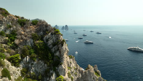 slow drone panning shot of steep rocks at italian island capri on a sunny day