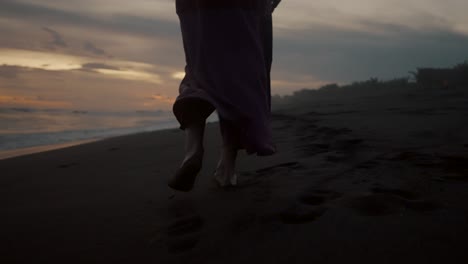 Eine-Frau,-Die-Bei-Sonnenuntergang-Am-Sandstrand-Spazieren-Geht