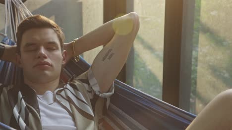 Man-Resting-And-Sleeping-In-A-Hammock-Indoors---close-up