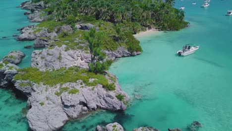 bermuda panning drone shot of rock formations and a boat in clear shallow water near morgan's island