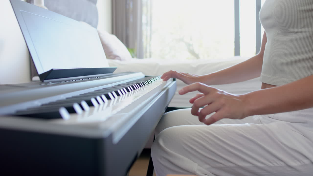 una adolescente caucásica está tocando un piano digital, aprendiendo una pieza