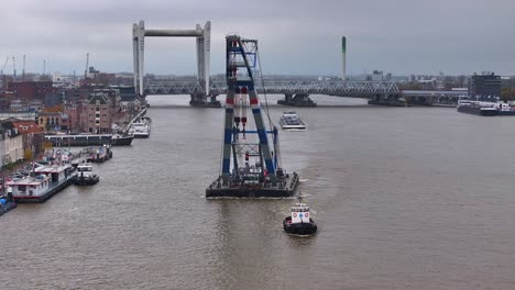 Maniobras-Del-Barco-Con-Propósito,-Guiando-Una-Grúa-Industrial-Más-Allá-De-Las-Aguas-De-Dordrecht.