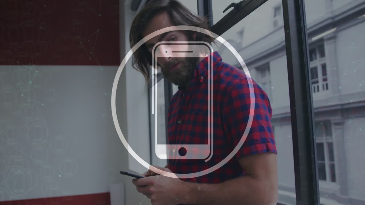 man holding smartphone inside tech office, displaying digital icon overlay and network patterns