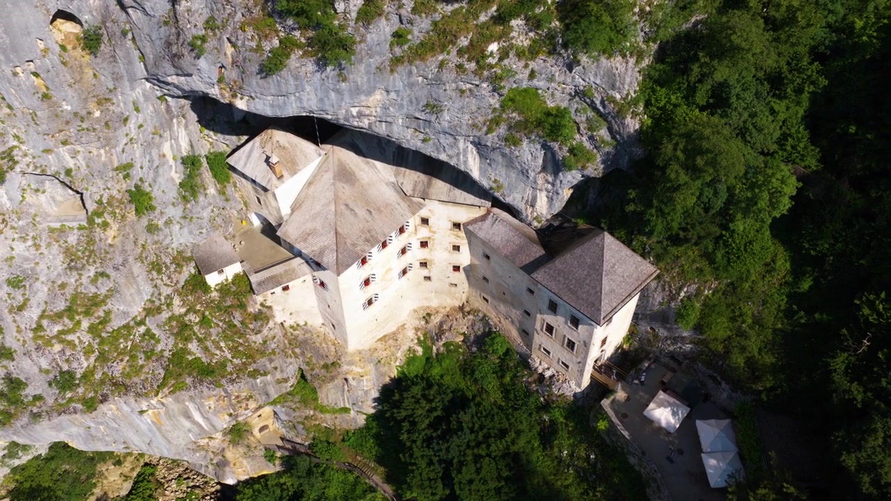Una vista dall'alto del Castello di Predjama mostra la fortezza medievale costruita nelle scogliere rocciose della regione della Carniola Interna in Slovenia. Ripresa aerea.