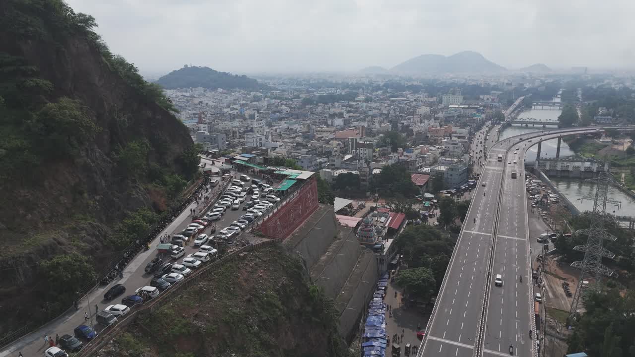Expansive drone shot of the Krishna River flowing under the historic Prakasam Barrage.