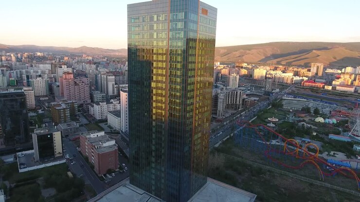 Ripresa aerea con drone ravvicinata di un lussuoso edificio in vetro al tramonto in Mongolia