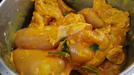 marinated raw chicken pieces infused with rich spices, ready to be cooked to perfection, releasing an irresistible aroma and flavor.