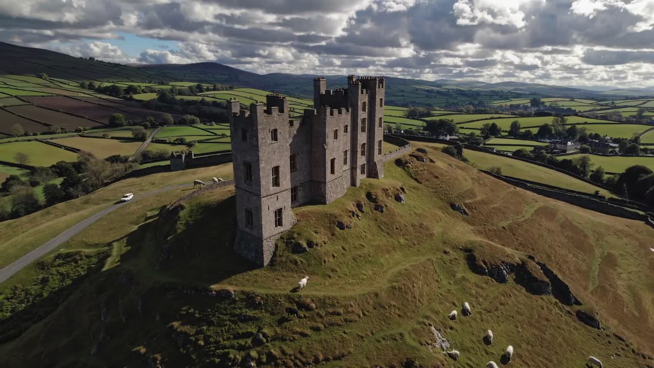 Aerial video captures a medieval castle on a hilltop, surrounded by lush countryside
