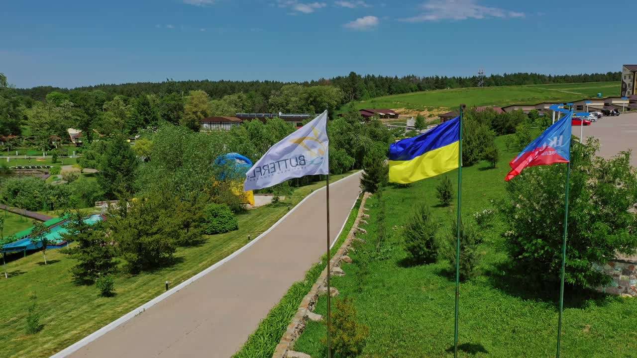 Ukrainian flag in the wind. Aerial view of national flag of Ukraine flies in the blue sky