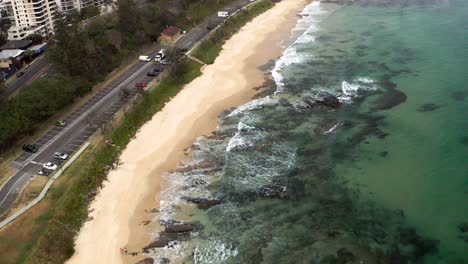 waves crashing on rocky coast of mooloolaba beach in maroochydore, sunshine coast region, queensland, australia