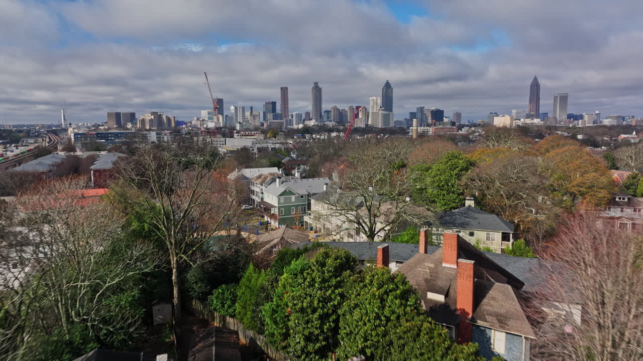 atlanta antena v778 vías de tren elevado de bajo nivel a través del vecindario residencial de inman park a lo largo del sendero de la línea de circunvalación con el paisaje urbano del centro en el fondo - filmado con cine mavic 3 - diciembre de 2021