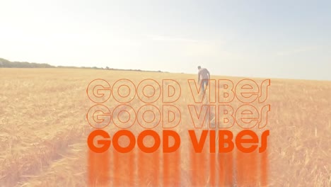 Animation-of-the-words-good-vibes-written-in-orange-with-man-walking-in-a-sunlit-cornfield