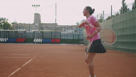 young caucasian woman playing tennis on a court returning a ball in slow motion