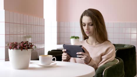 hermosa y elegante mujer caucásica usando una tableta, enviando mensajes de texto, escribiendo. sonriendo, mirando hacia otro lado 60 fps