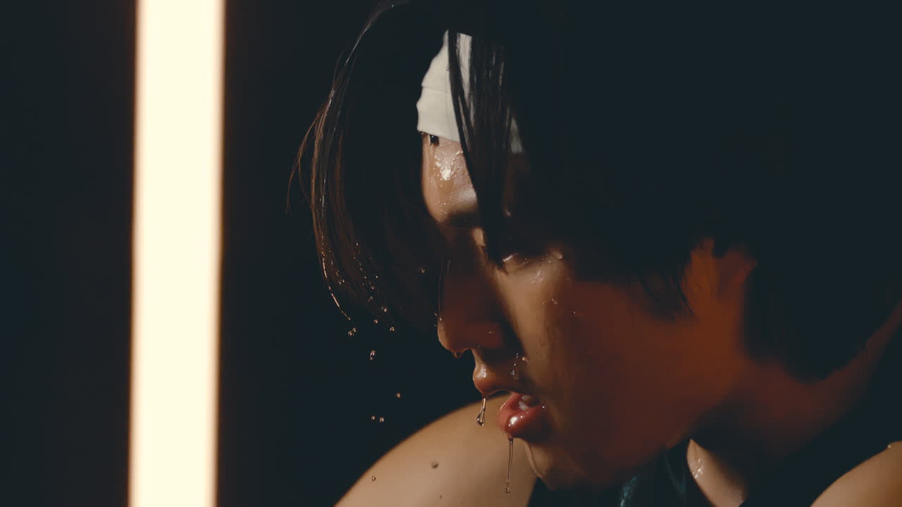 atleta masculino asiático goteando sudor después de un duro entrenamiento, primer plano de la cara en 4k 800fps movimiento lento extremo