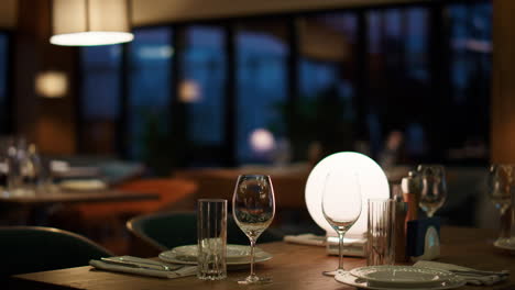 mesa de restaurante de hotel moderno en el café de la noche. mujer esperando una cena romántica