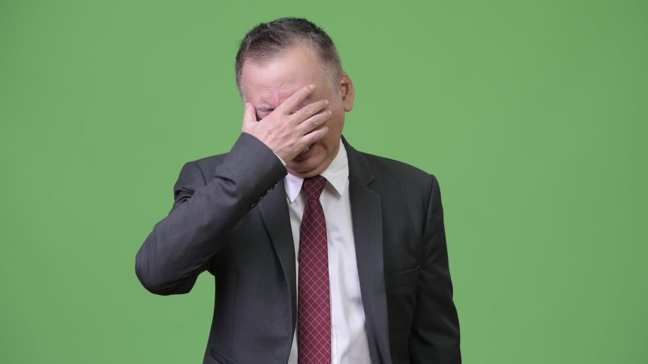 눈을 감고 울고 있는 성숙하고 슬픈 일본인 사업가