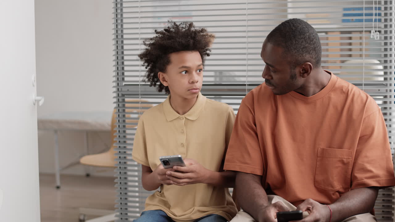 hombre y niño africanos hablando en el interior