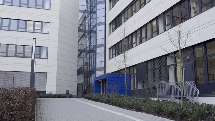 Persone che entrano ed escono dall'ingresso di un moderno edificio del campus universitario