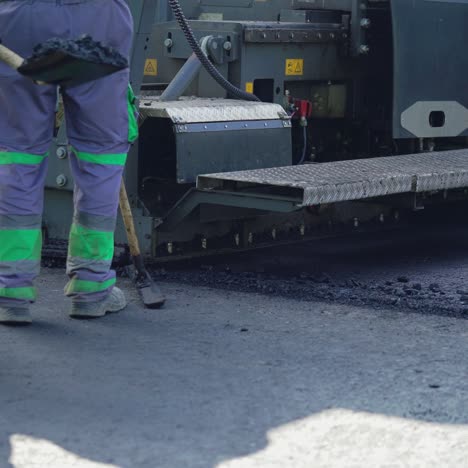 workers are laying asphalt on the road against the background of the machine for paver. road repair work in process