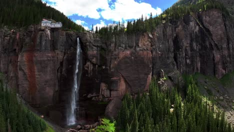 telluride bridal veil falls waterfall colorado powerplant house aerial drone down motion shade aspen trees uncompahgre forest summer green box canyon black bear pass road rocky mountains 4wd blue sky