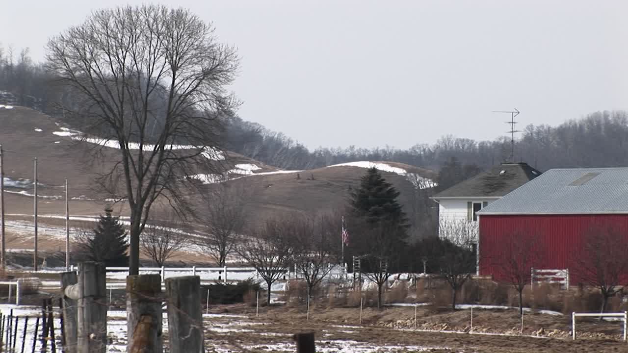 la cámara recorre una granja estadounidense con graneros y silos rojos