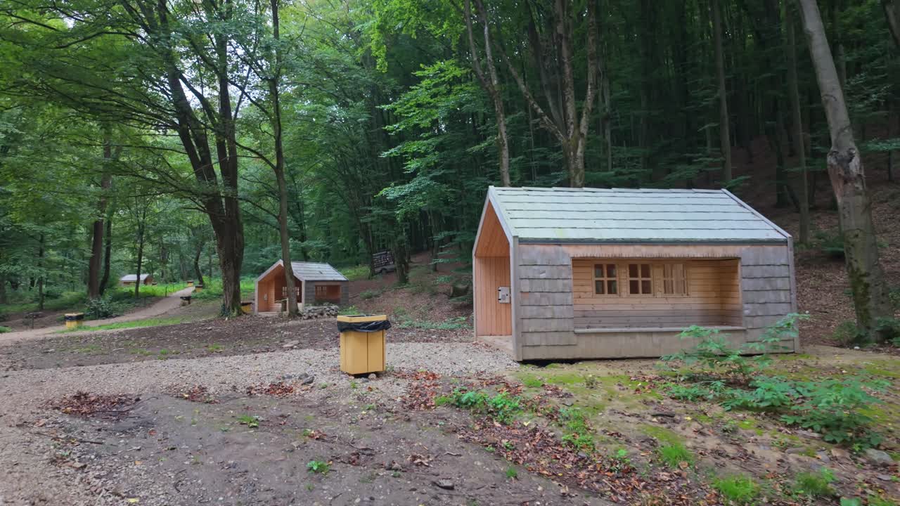 Scenic wooden cabins nestled in a lush forest in Vadu Crișului, Romania, offering a tranquil retreat surrounded by greenery and the serene beauty of Eastern Europe's countryside